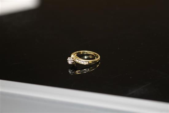 A modern 18ct gold and single stone diamond ring, with diamond set shoulders, size L/M, gross weight 3 grams.